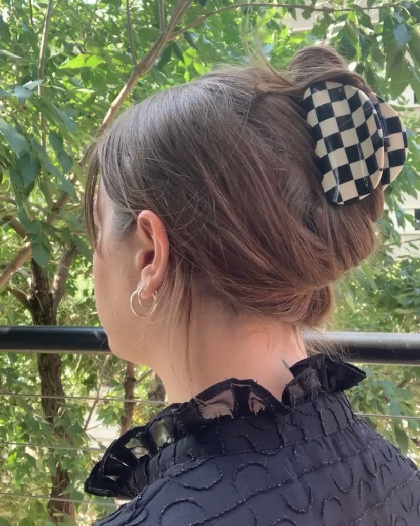 Black and white checkered claw clip holding hair in an updo.