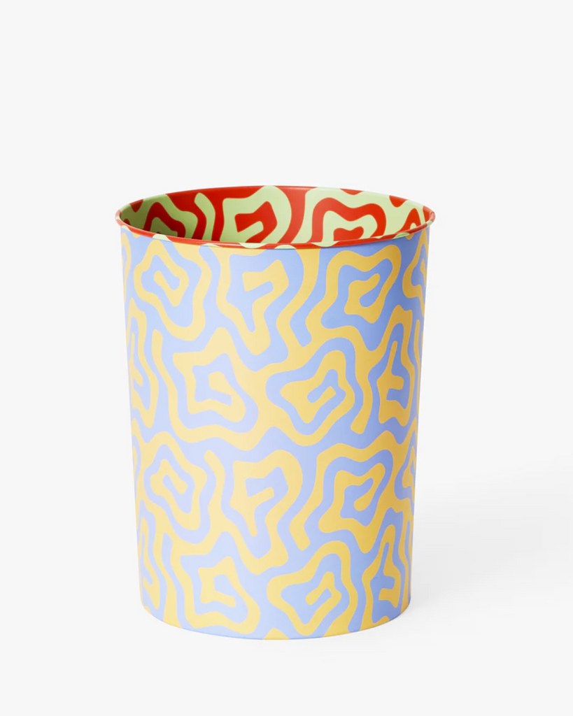 The spiral pattern bin with a white backdrop. The bin is patterned in a light blue and yellow wiggle spiral. The inside has the same pattern but in red and light green colors. 