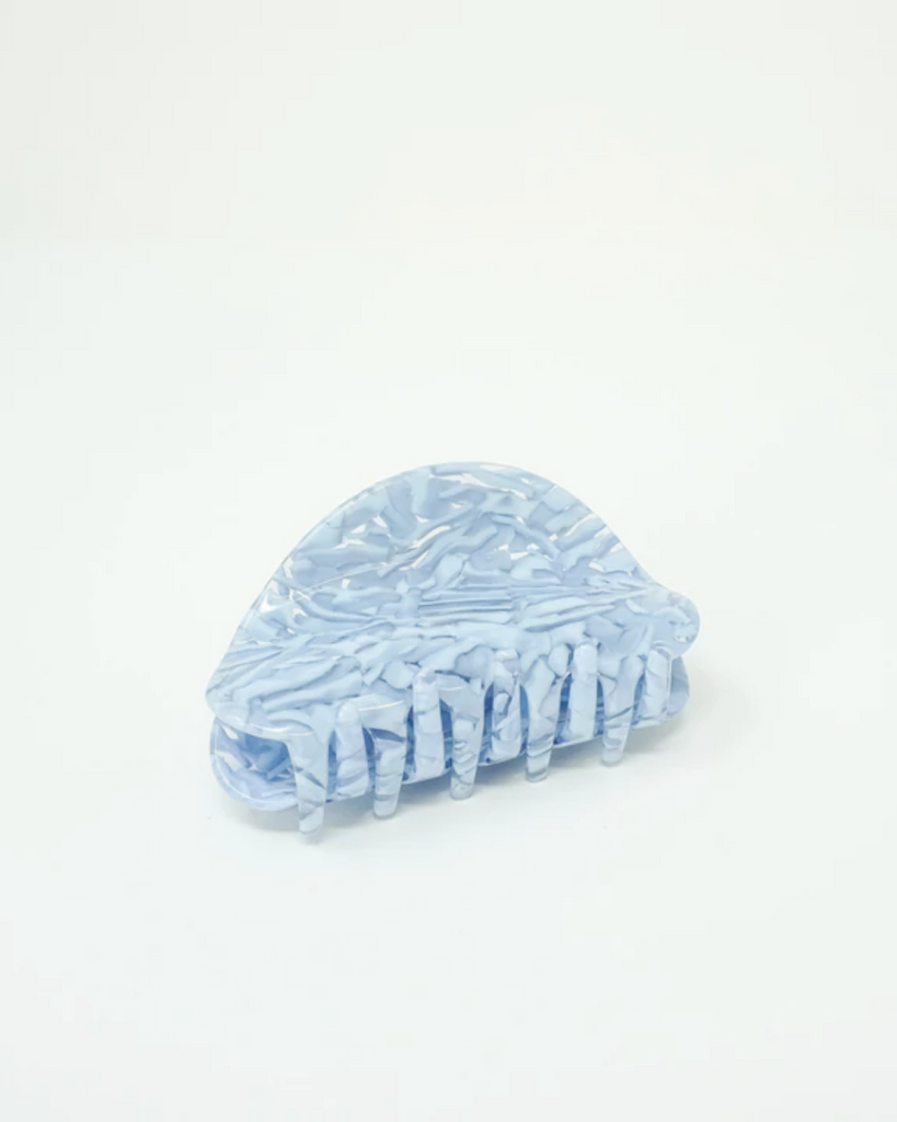 Frostbite claw clip has a baby blue and clear marble pattern. Shown on a white backdrop. 