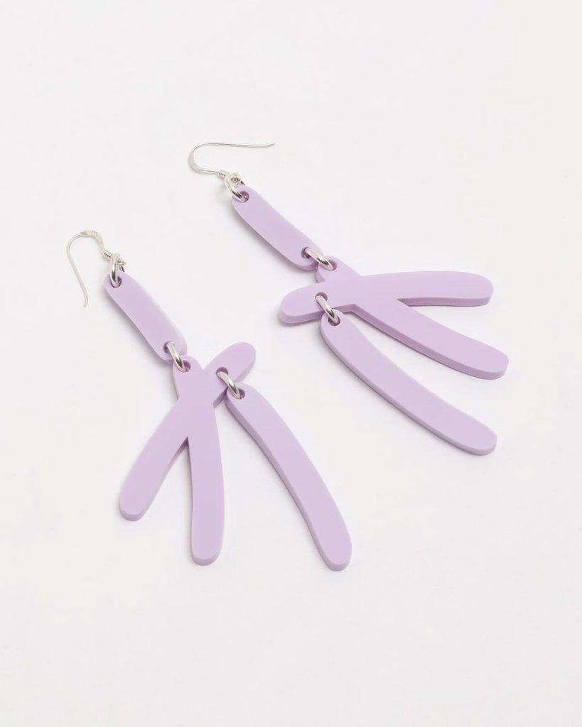 The Lilac earrings are shown on a white surface. The earrings are a unique abstract shape of rounded lines joined together.