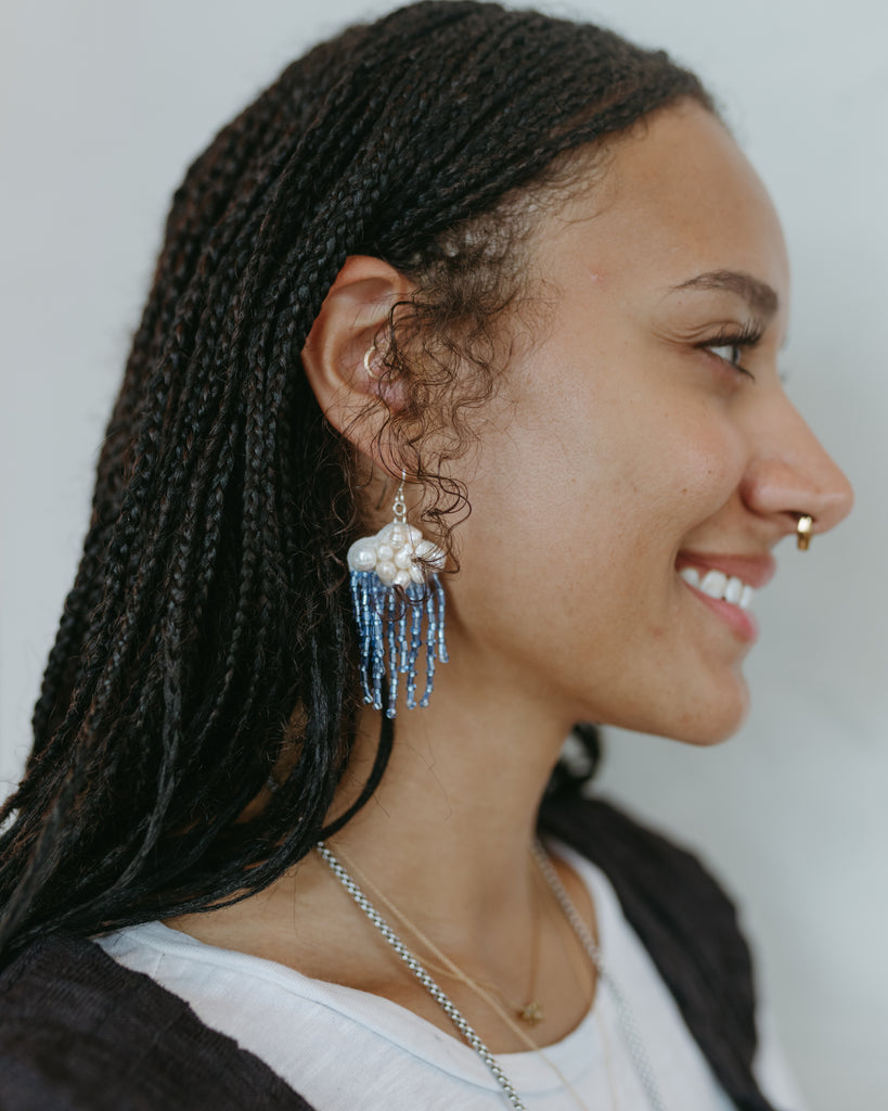 Model, Zaria, shown smiling in profile view wearing the cloud earring.